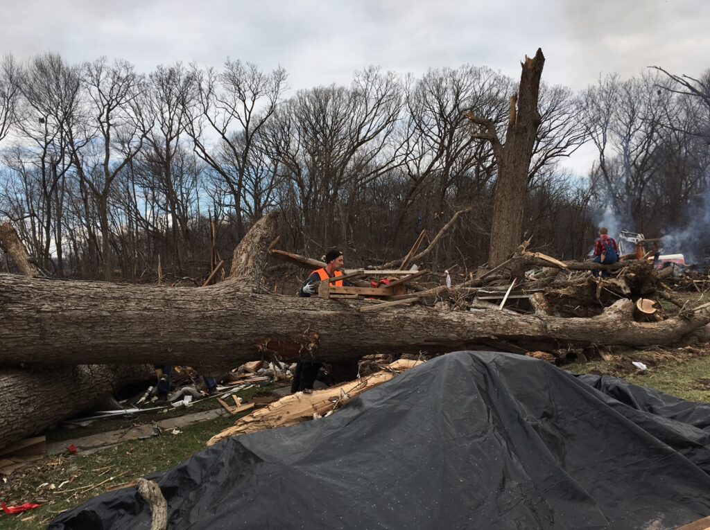 Volunteers cut up fallen trees in East Moline, IL after a deadly Tornado.
